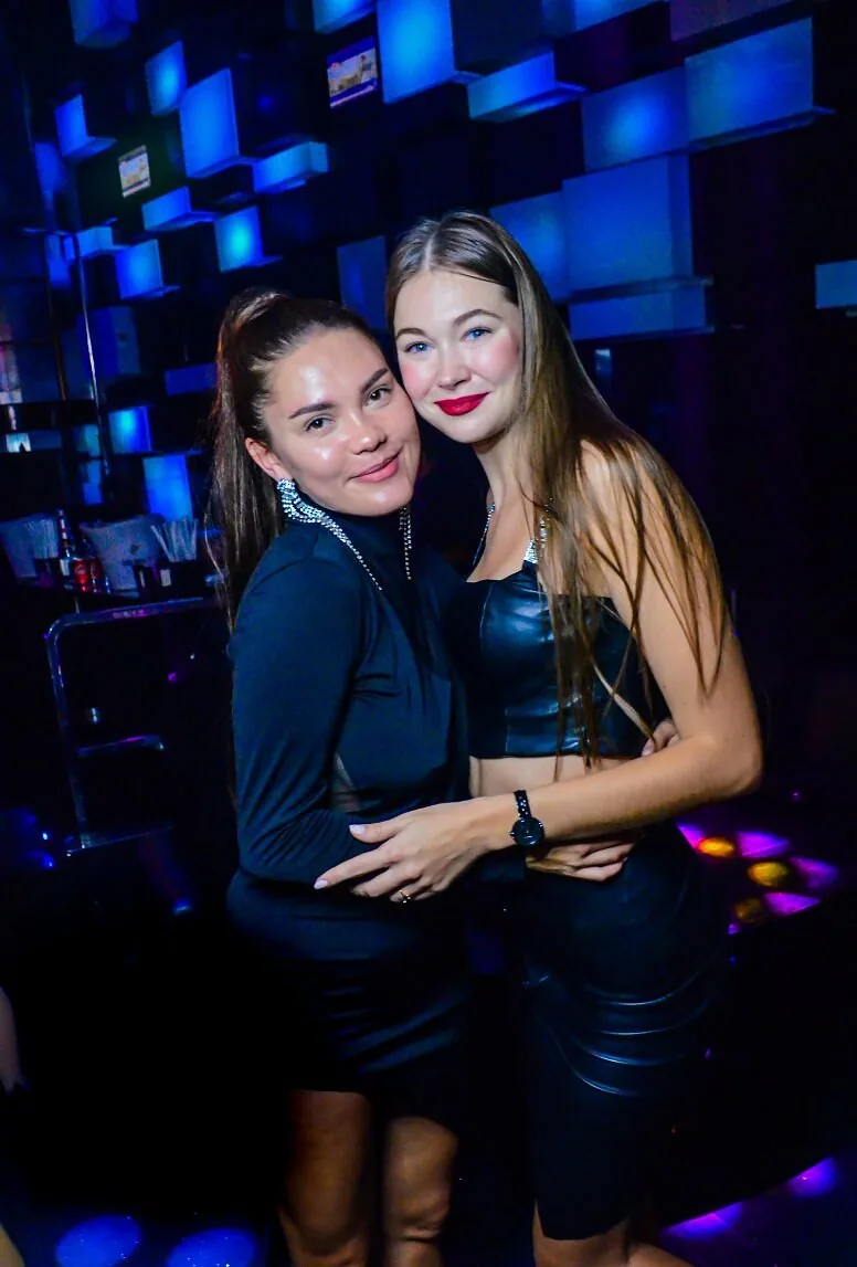 Two guests posing against blue LED walls at Chameleon Club Dubai